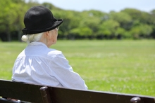 老人が公園で座っているイメージ写真